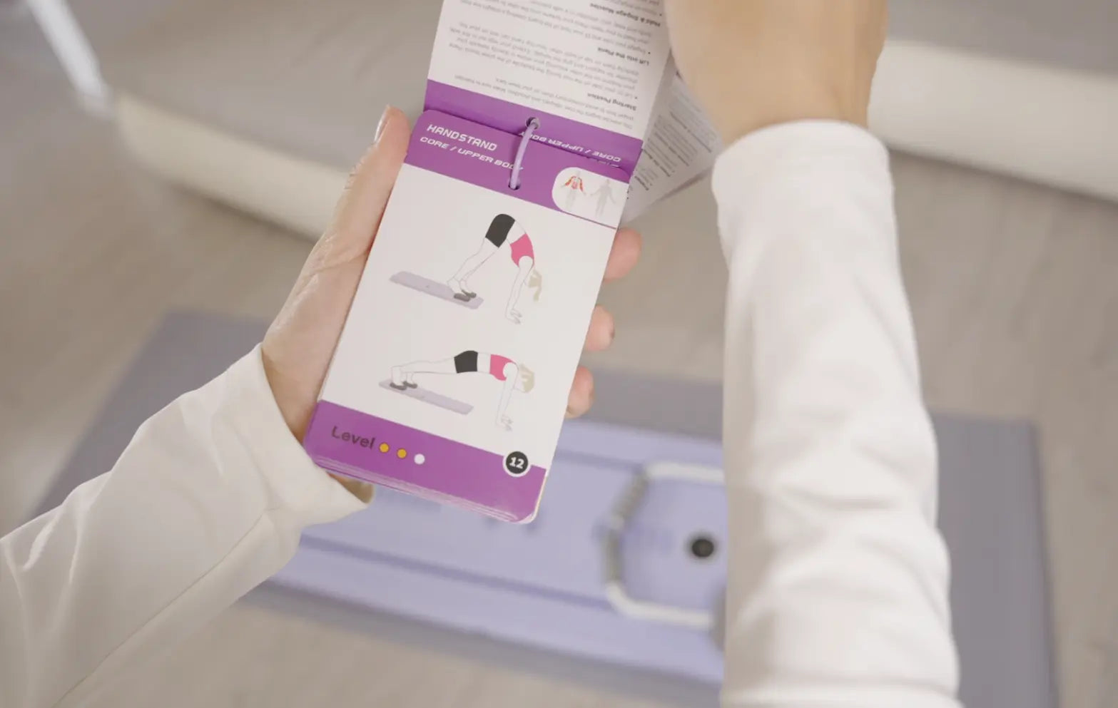 foldable pilates board Exercice instruction cards hold by women